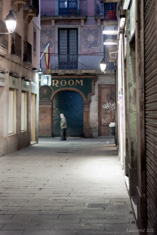 An old man walking by night in Barcelona Gothic Quarter